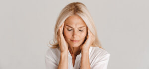 mulher com mão na cabeça por dor