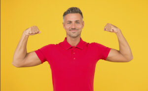 homem de cerca de 40 anos com bons níveis de testosterona exibindo os músculos do braço