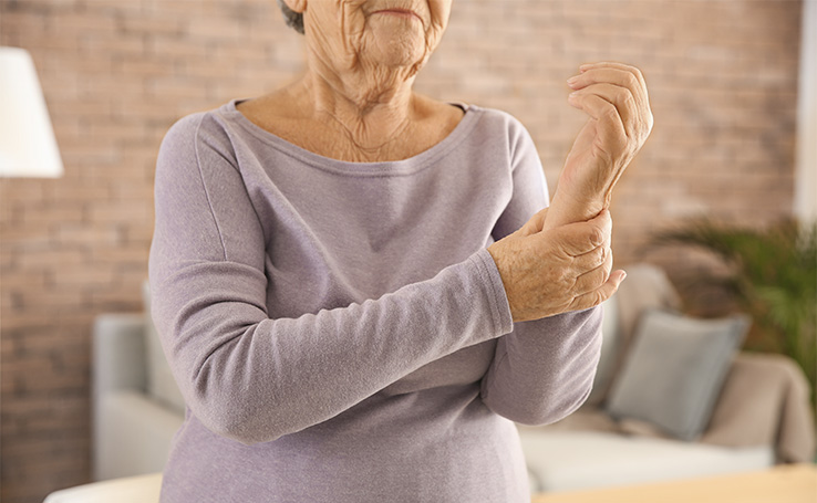 idosa pressionando o punho por estar com dor, um sintoma de osteoporose