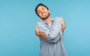 Homem abraçando a si mesmo como um sinal de uma boa autoestima.